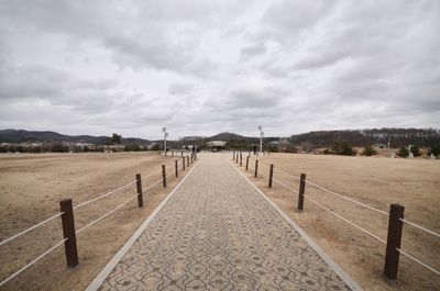 Empty footpath against sky