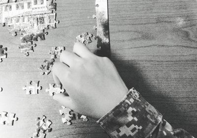 Cropped hand of person playing puzzle at table