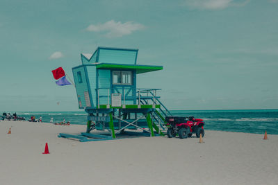 Lifeguard hut on beach against sky