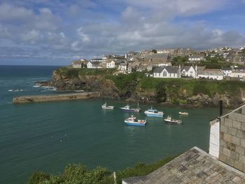 Boats in sea against cloudy sky