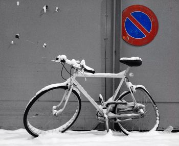 Bicycle sign on road against wall