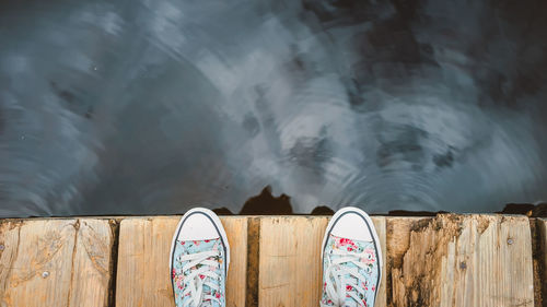 Low section of man on pier over lake