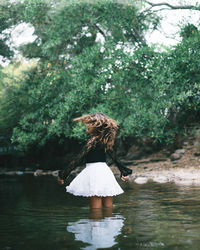 Rear view of woman standing in lake