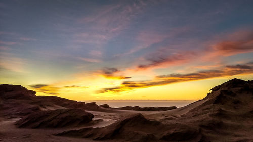 Scenic view of desert against sky during sunset