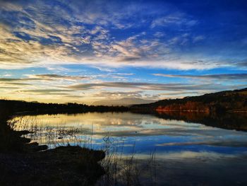Scenic view of lake against sky at sunset
