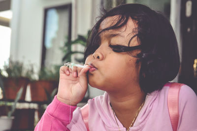 Close-up portrait of woman holding cigarette