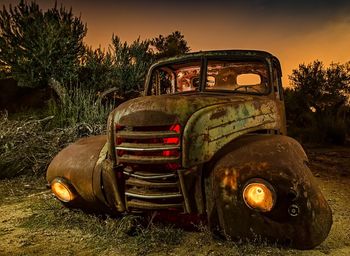 Abandoned vintage car on field against sky