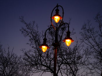 Low angle view of illuminated street light against sky