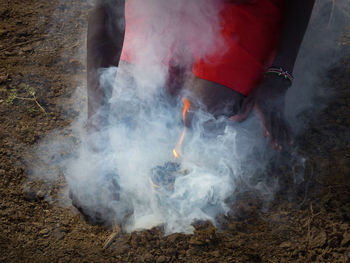 Low section of man standing by smoke on land