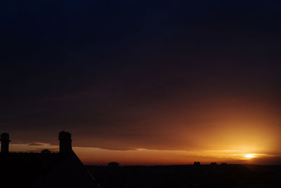 Silhouette buildings against sky during sunset