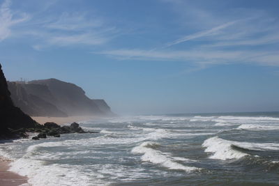 Scenic view of sea and mountains against sky