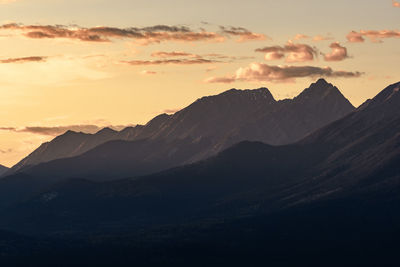 Scenic view of silhouette mountains against sky at sunset