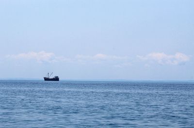 Sailboat sailing on sea against sky