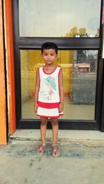 Portrait of a smiling girl standing against door