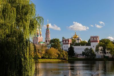 Scenic view of river by buildings against sky