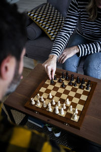 Woman and man playing chess at home