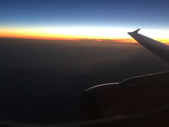 Cropped image of airplane flying over cloudscape