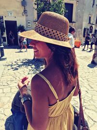 Rear view of woman with hat on street in city