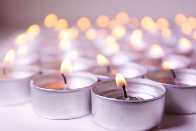 Burning tea light candles on table