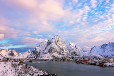 Scenic view of snowcapped mountain by sea against sky