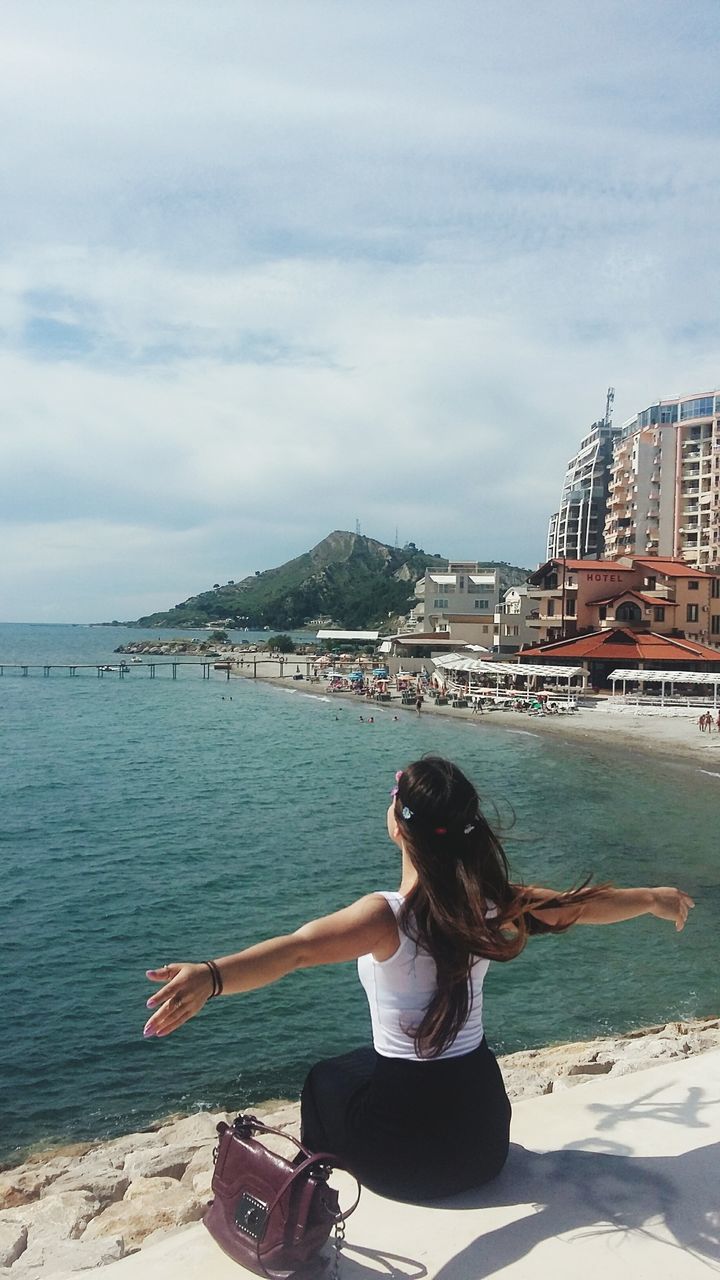 YOUNG WOMAN STANDING BY SEA