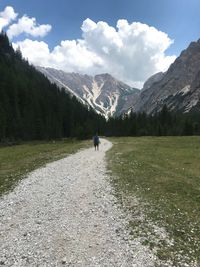Scenic view of person walking on land against sky