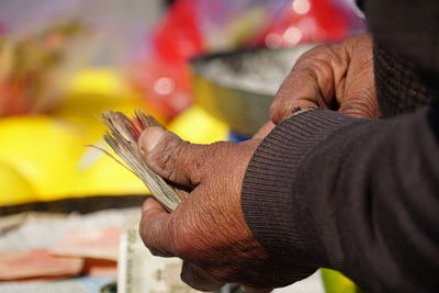 Close-up of man holding paper currency at shop