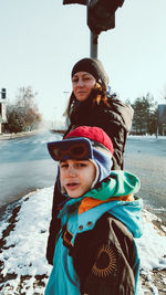 Portrait of mother and son standing on footpath during winter