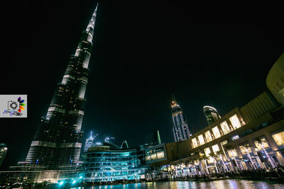 Low angle view of illuminated buildings against sky at night