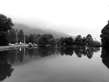 Scenic view of lake by trees against sky