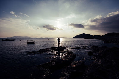 Silhouette man on beach against sky