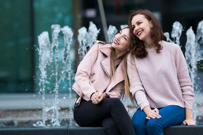 Smiling friends sitting outdoors