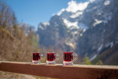 Wine glasses on table against mountain range