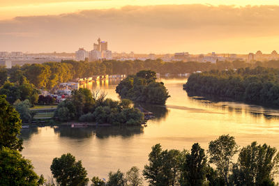 Scenic view of river against cloudy sky at sunset