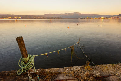 Wooden posts in sea against sky