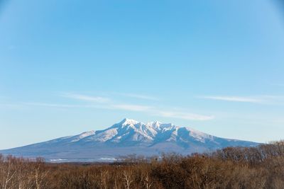Scenic view of snowcapped mountains against blue sky