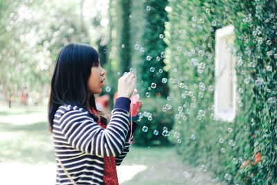 Young woman blowing bubbles