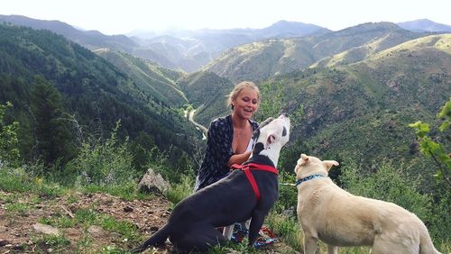 Portrait of woman with dog sitting on mountain