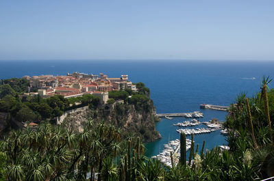 High angle view of town by sea against clear sky