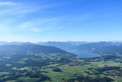 Aerial view of landscape and mountains against blue sky