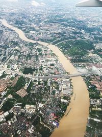 Aerial view of river amidst cityscape against sky