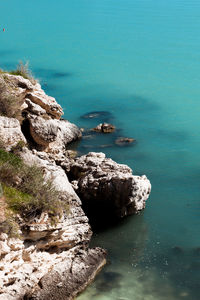 Rock formation by sea against sky 