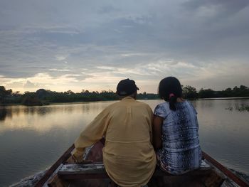 Rear view of couple on lake against sky