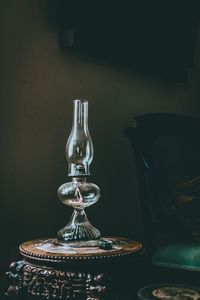 Close-up of old electric lamp on table against wall