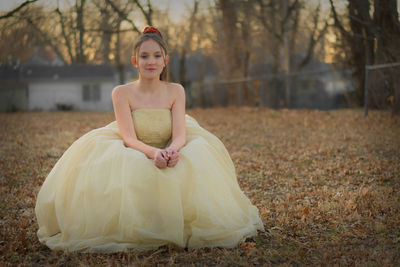 Portrait of young woman standing on field