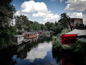 River amidst trees and buildings against sky