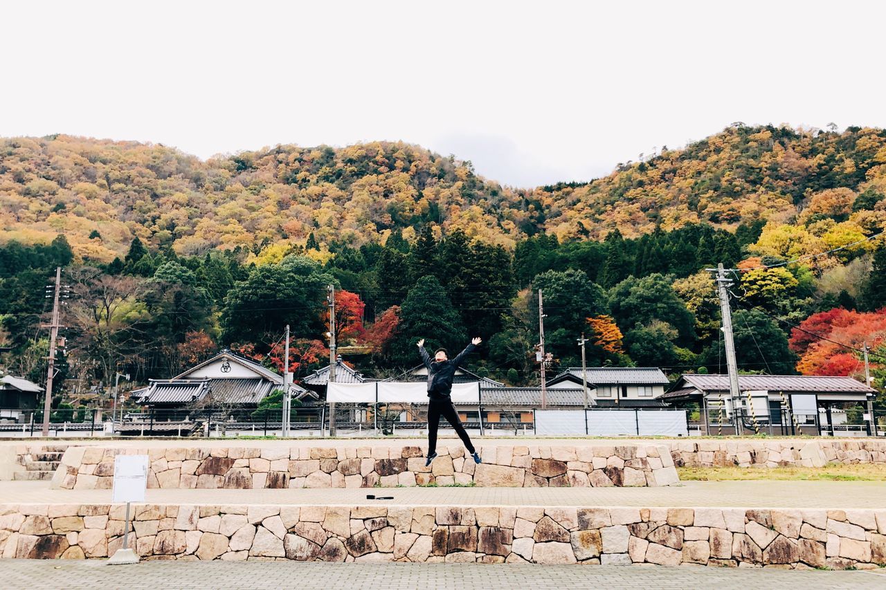 tree, plant, architecture, built structure, one person, sky, nature, real people, building exterior, lifestyles, day, men, standing, full length, outdoors, leisure activity, change, autumn, adult