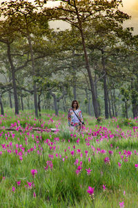 Woman standing by flowering plants