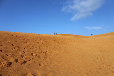 Scenic view of desert against blue sky