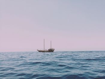 Sailboat sailing on sea against clear sky